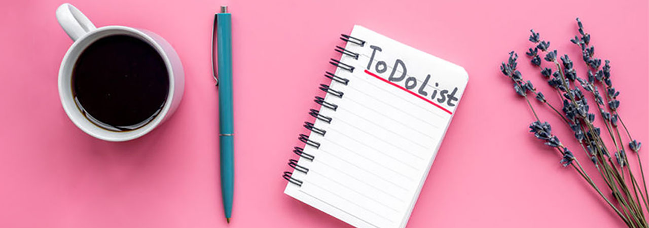 pink background with coffee pen and to do list notebook